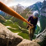 woman climbing rocks using climbing rope